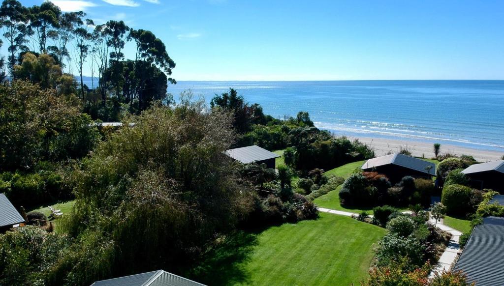 科灵伍德Adrift In Golden Bay- Absolute Beachfront Villas的享有房子和海滩的空中景致