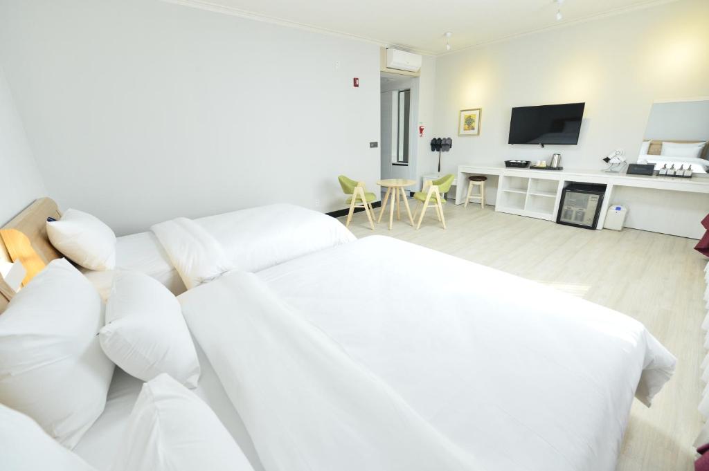 光州Gwangju Tourist Hotel的白色的客厅配有白色的沙发和电视