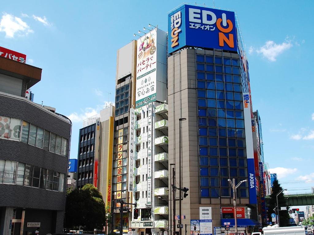 东京Anshin Oyado Tokyo Akihabara Denkigaiten- Male Only的一座高大的建筑,旁边有一个标志