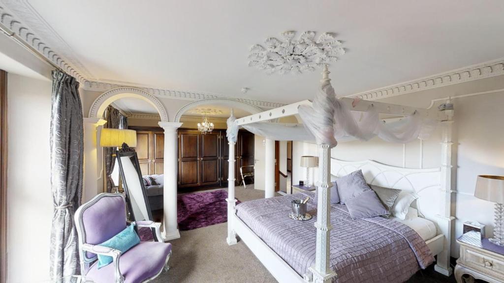 红山Redhill House BRS Airport的一间卧室配有一张天蓬床和一张紫色椅子