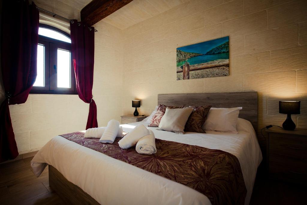 阿尔卜Soleil B&B Gozo的卧室配有带白色枕头的大床
