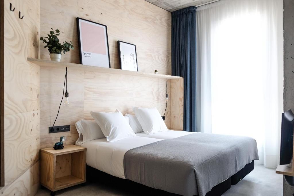 圣塞瓦斯蒂安Talo Urban Rooms的卧室设有一张白色大床和一扇窗户。