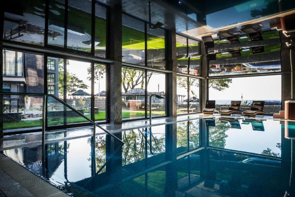 尤斯托尼莫斯基Max Health Resort SPA的一座带窗户的建筑中的游泳池