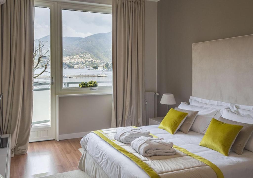 科莫Como Lake Suites的一间卧室设有一张大床和大窗户