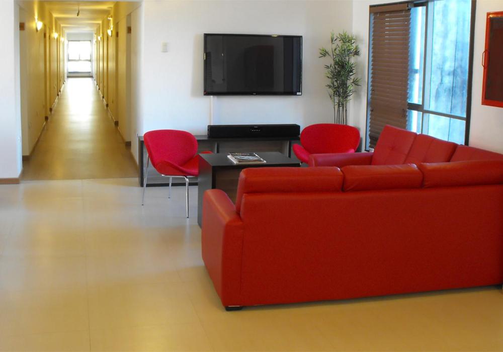 康塞普西翁罗曼诺酒店 的客厅配有红色沙发和红色椅子