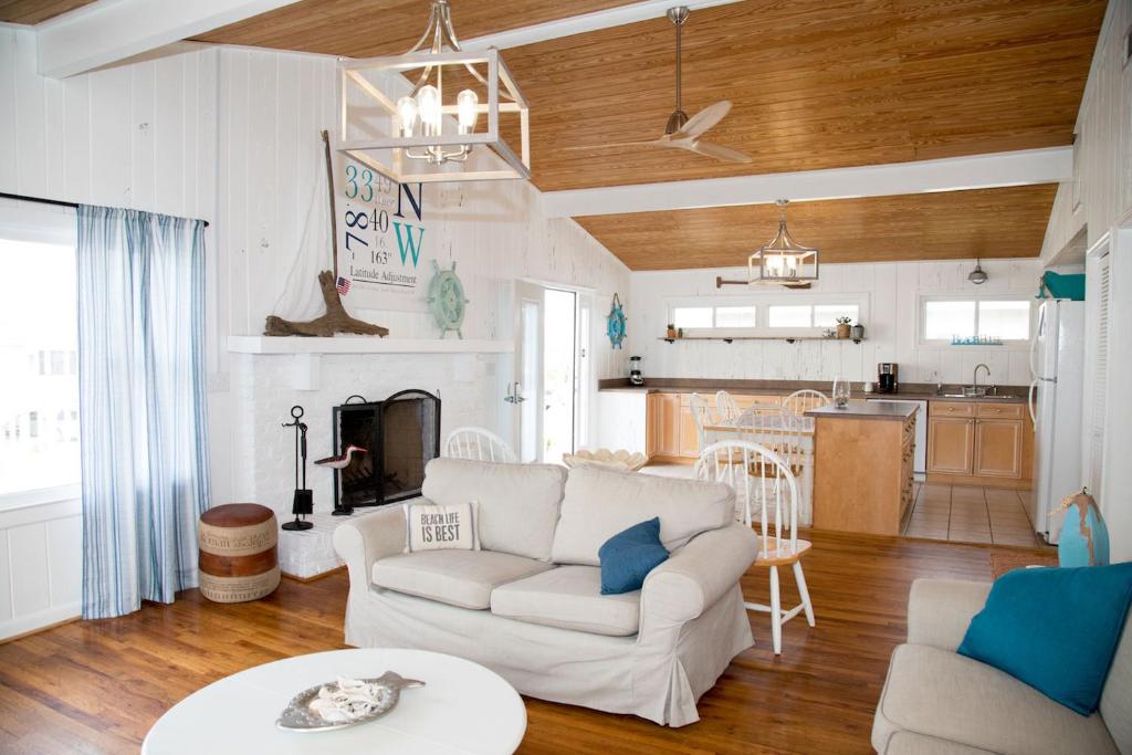 默特尔比奇Latitude Adjustment的一间带白色沙发的客厅和一间厨房