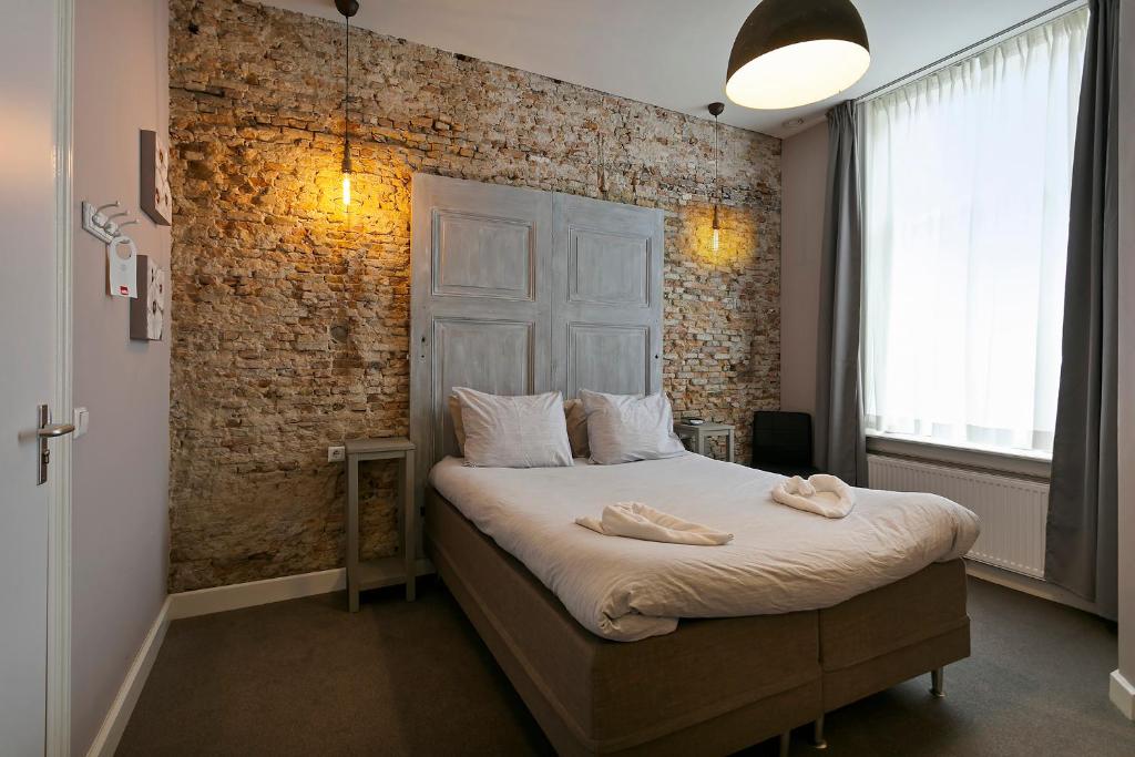 拉姆斯东克斯费尔赫尔酒店的一间卧室配有一张砖墙床
