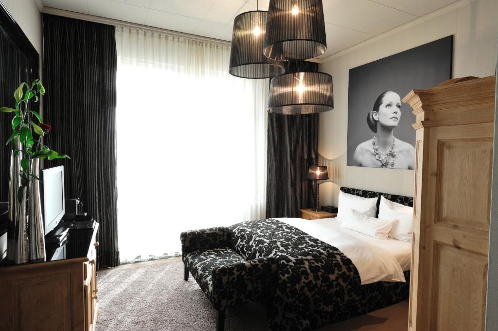杜塞尔多夫第47舞台酒店的一间卧室设有一张床和一个大窗户
