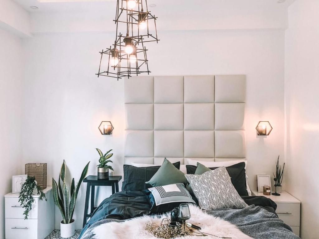 麦克坦Soderberg ( Near Airport | 50mbps Wifi | Netflix )的一间卧室配有一张床和一个吊灯