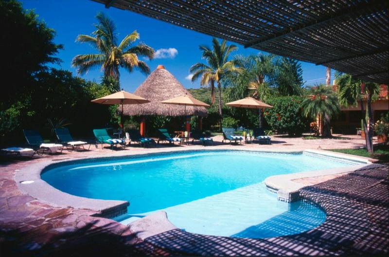 绍其德贝克马尔利之家B＆B旅馆的一个带遮阳伞和椅子的游泳池以及一个度假村