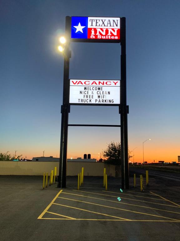 莫纳汉斯Texan Inn and Suites Monahans的停车场的德州公司标志