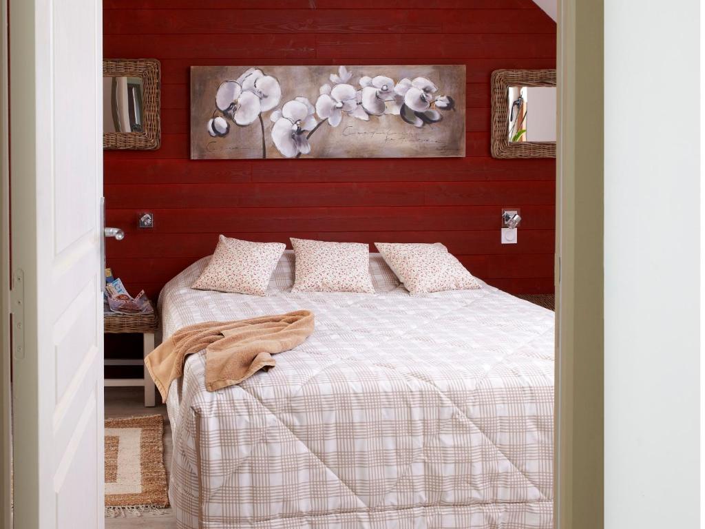 普卢加穆瓦桑Domaine Le Puits De Jeanne的一间卧室配有一张红色墙壁的床