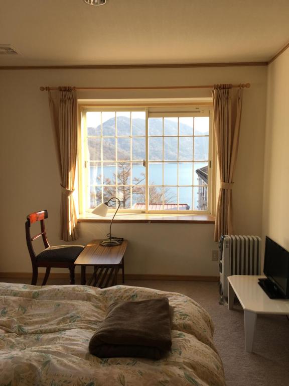 日光日光小森林旅馆的一间卧室设有一张床和一个大窗户