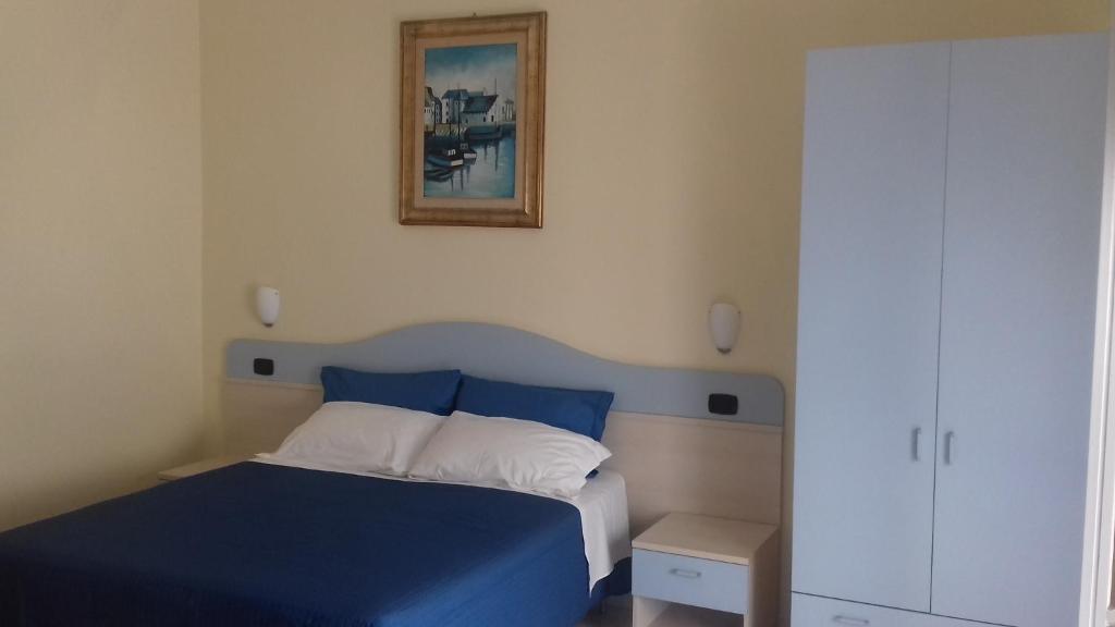 玛格丽塔萨沃亚La Rosa Dei Venti的卧室配有蓝色的床,墙上挂着一幅画