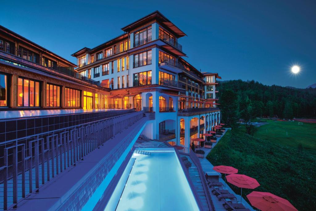 厄茂Schloss Elmau Luxury Spa Retreat & Cultural Hideaway的一座大型建筑,前面设有一个游泳池