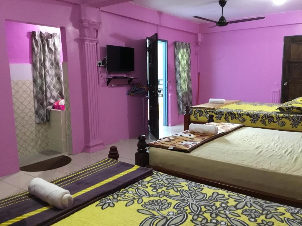 仙本那Family Room (Pakej G2)的一间设有两张床和紫色墙壁的客房
