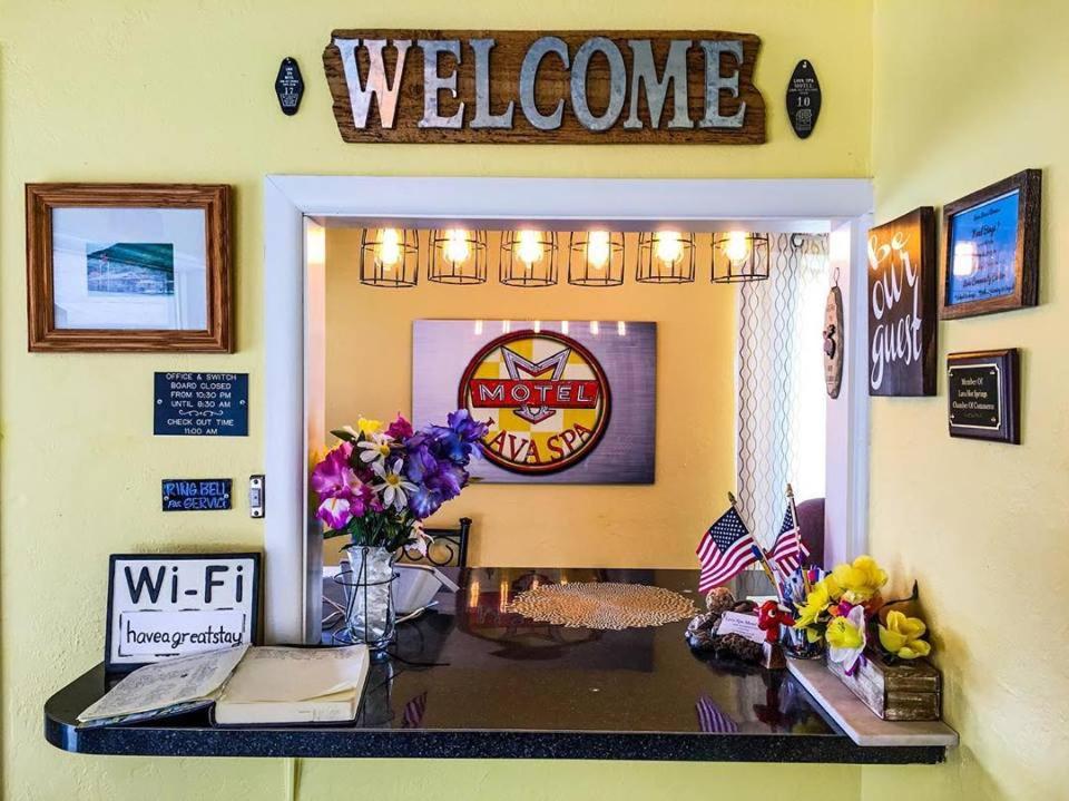 熔岩温泉村Lava Spa Motel & RV的墙上的带迎宾标志的桌子