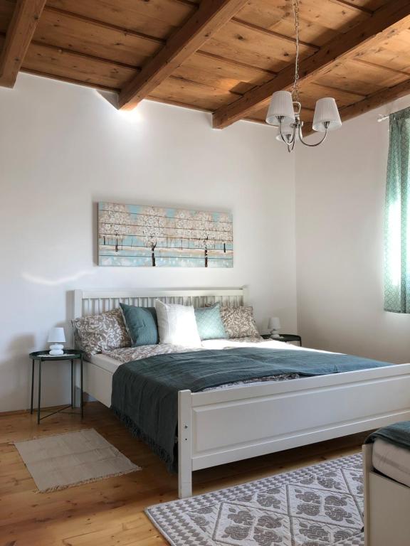 艾格扎洛克Twin Pines Apartment的一间带一张大床的卧室,位于一个拥有木制天花板的房间