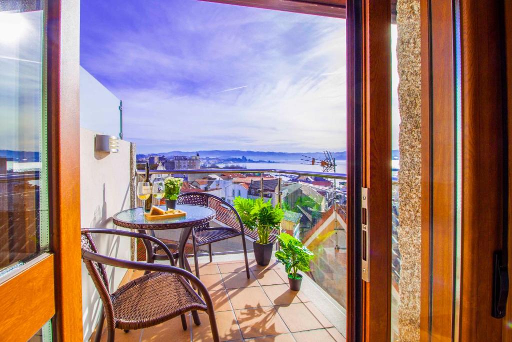 坎加斯德穆拉索Casa do Outeiro的设有一个配有桌椅并享有美景的阳台。