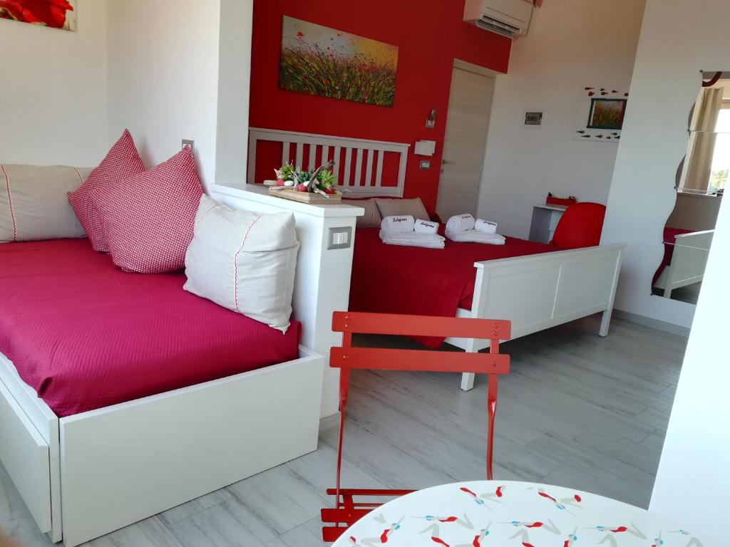 马西亚娜马里纳B&B Capo al Piano的带沙发和红色墙壁的客厅