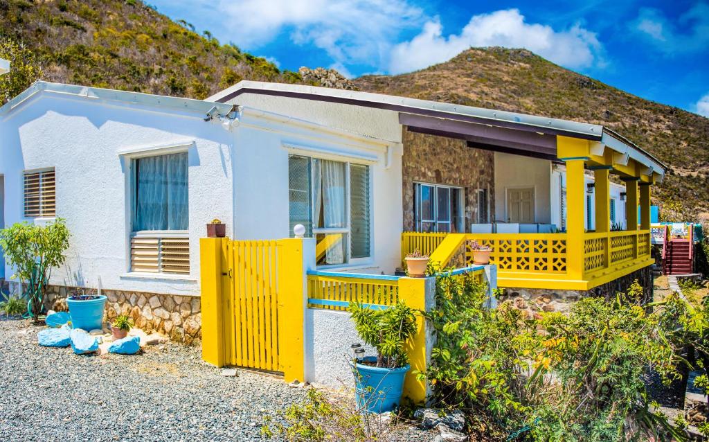 Upper Princeʼs QuarterVilla Fleur De Mer Sint Maarten的一座黄色房子,后面有山