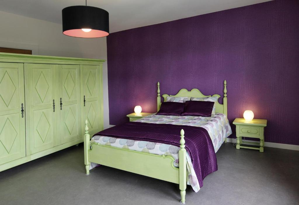 Herve乌埃布弗勒公寓的一间卧室设有紫色墙壁和一张带两盏灯的床