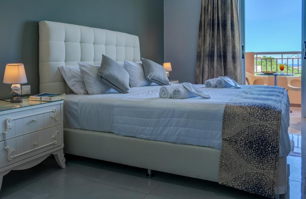 蒂锡利维万神殿酒店的卧室配有一张白色大床、梳妆台和窗户。