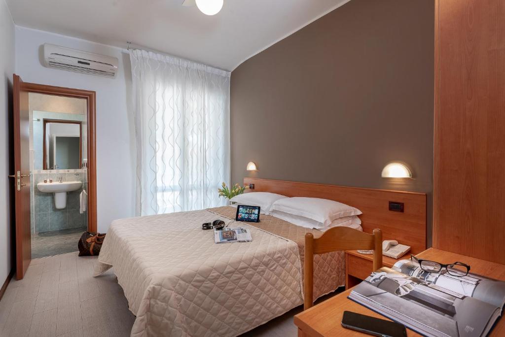 里乔内皮埃尔酒店的酒店客房设有一张床和一张带笔记本电脑的书桌