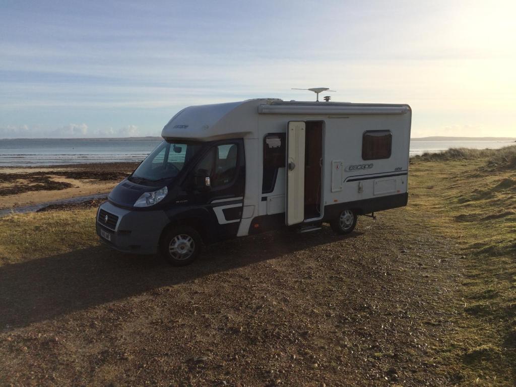 斯托诺韦Four Berth Motorhome Isle of Lewis的停放在海滩上的小型白色大篷车