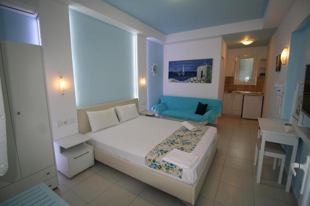 艾斯普罗瓦塔Alexandros Studios的卧室配有白色的床和蓝色的沙发