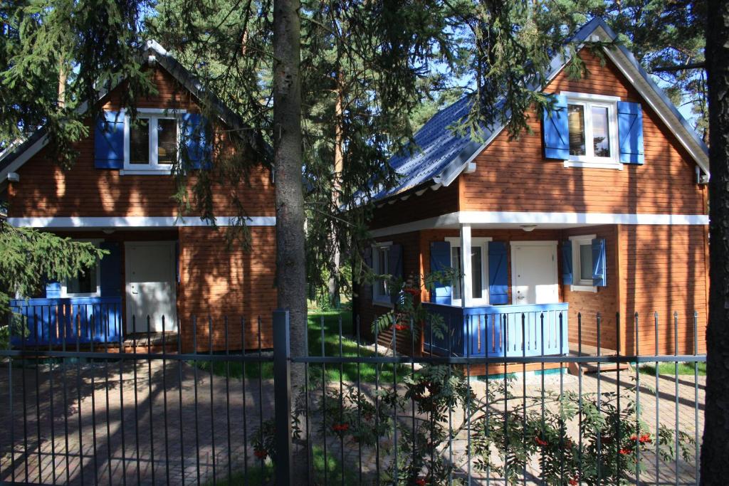 波别罗沃domki letniskowe Gnieźnieńska Pobierowo的前面有围栏的房子