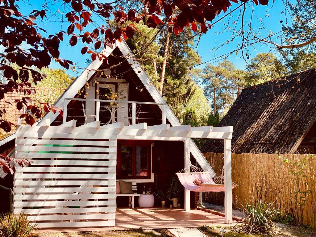 SzigetmonostorNadi's Holiday Home – Heart of Woods, Szentendre Island的前面有一张粉红色椅子的白色游戏房