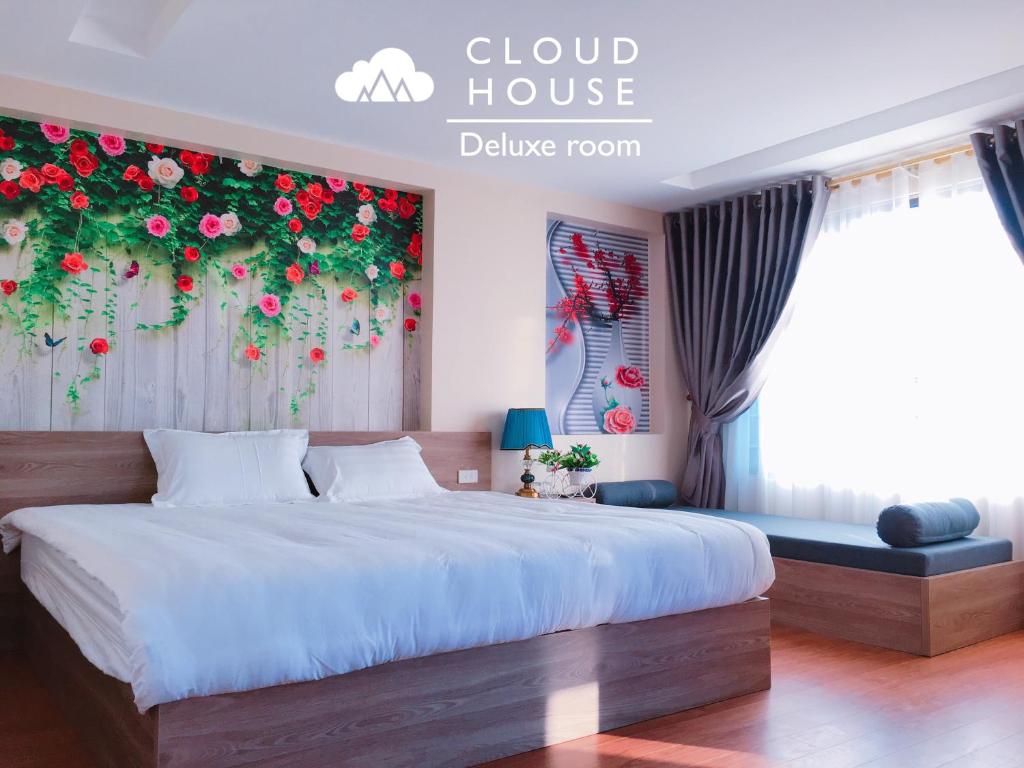萨帕Cloud House Sapa的卧室配有一张挂着红色鲜花的床。