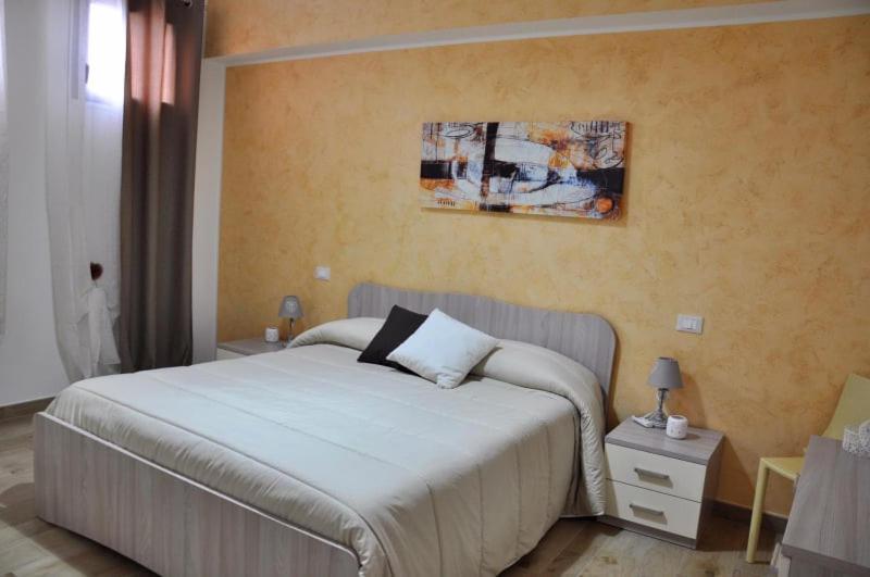 利扎诺House Le Fontanelle的卧室配有一张床,墙上挂有绘画作品