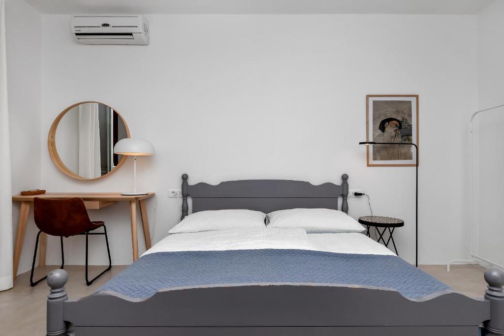 马卡尔斯卡Apartments & Rooms Rica的一间卧室配有一张大床和镜子