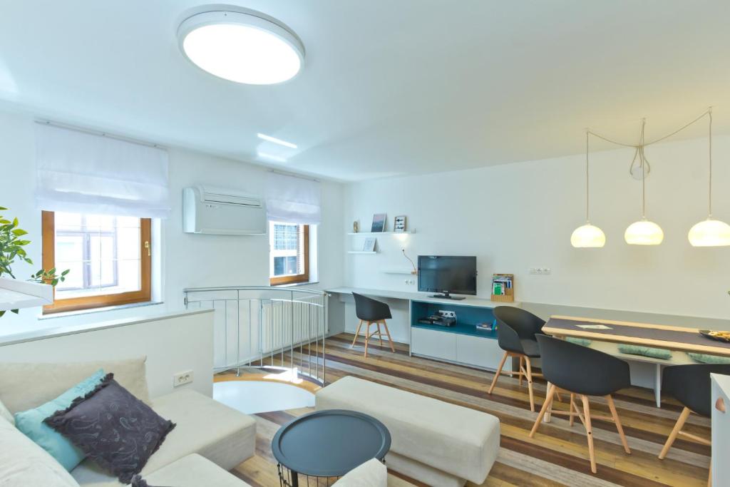 卢布尔雅那城市中心公寓的客厅配有沙发和桌子