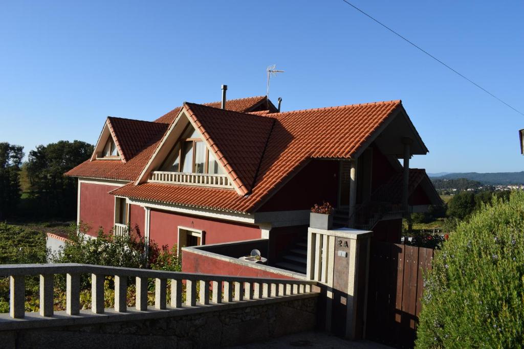 Santa CristinaCasa De Campo Clara的一座红色屋顶和围栏的房子