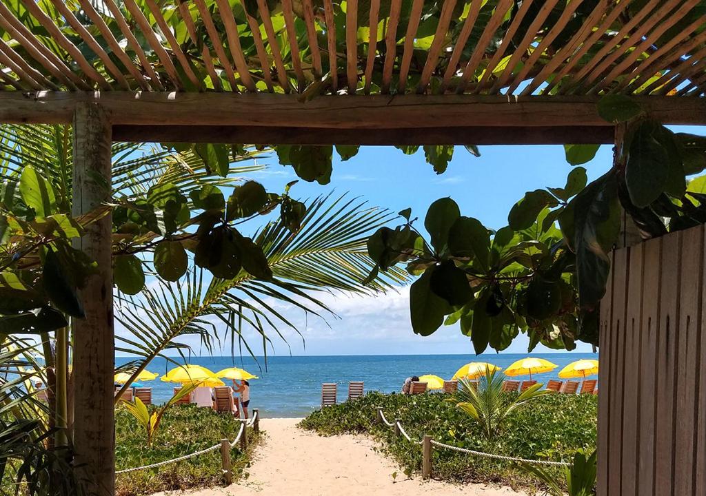圣安德烈Vila Araticum Praia的享有海滩美景,配有遮阳伞和海洋美景。