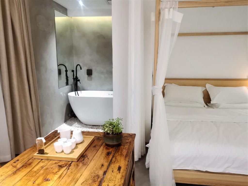 成都木来精品酒店的一间带浴缸、一张床和一张桌子的卧室