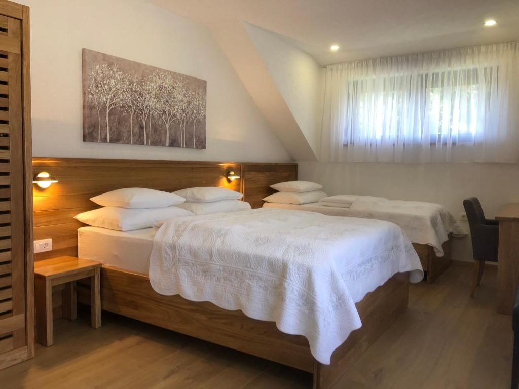 普利特维采湖普利维斯米利斯旅馆的一间卧室配有两张带白色床单的床