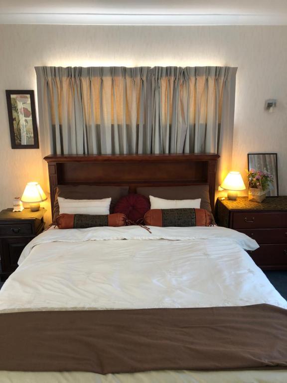 上哈特A Cozy Room with It's Own Privacy的一间卧室配有一张带两盏灯的大型白色床。