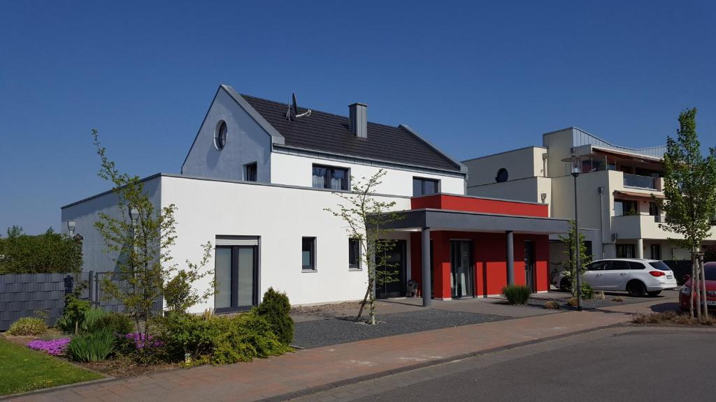 克桑滕Haus am Prekkesee的一座白色的大建筑,设有红色的门