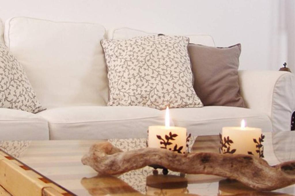 埃尔米奥尼artística的客厅配有沙发和咖啡桌上的蜡烛