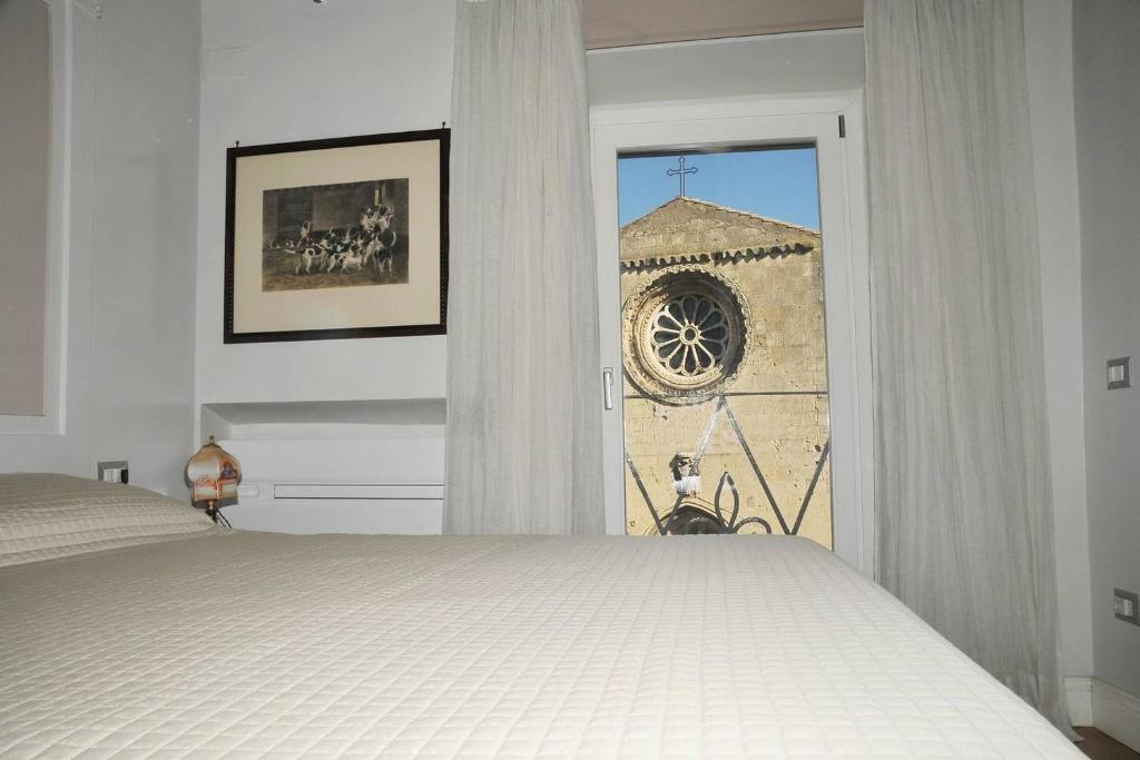 塔尔奎尼亚Camere con vista (Rooms with a view)的一间卧室配有一张床,享有教堂的景色