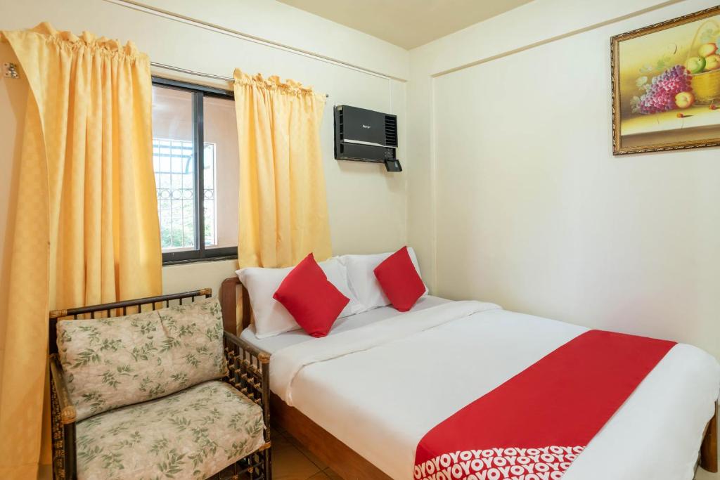 马尼拉Conrado's Apartelle的卧室配有床、椅子和窗户。