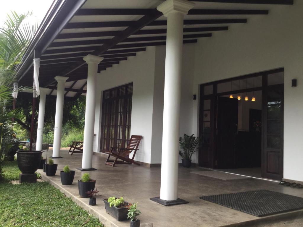 KiribatkumburaKandyan Lounge的柱子和植物的房屋门廊