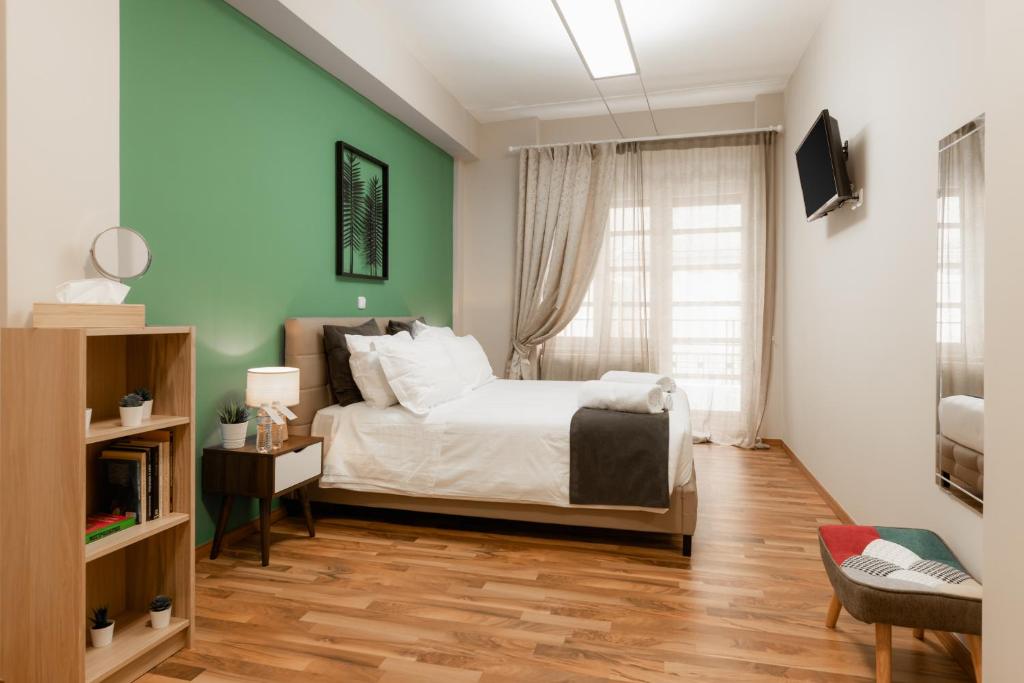雅典Monastiraki Urban Apartments的一间卧室设有一张床和绿色的墙壁