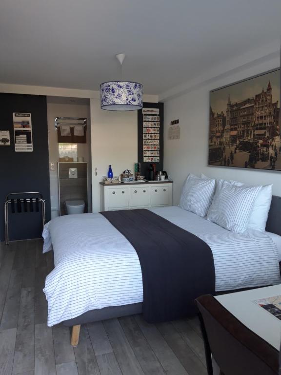 阿姆斯特丹加米住宿加早餐旅馆的卧室配有一张白色的大床和一张桌子