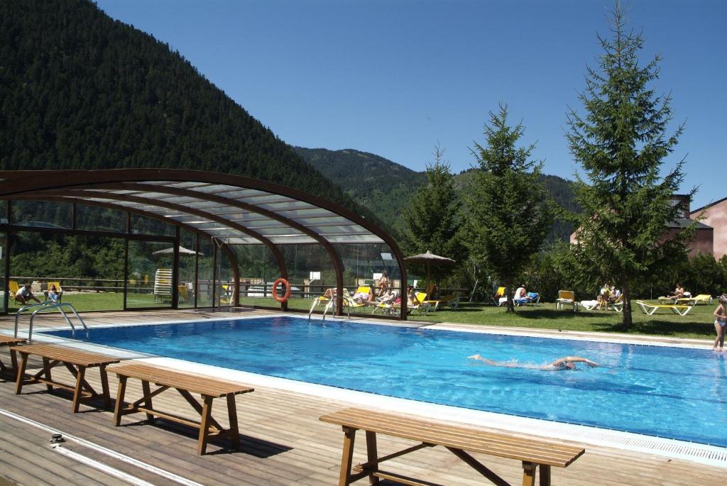 巴奎伊拉-贝莱特蒙塔图酒店的一个大型游泳池,里面设有长椅和人手
