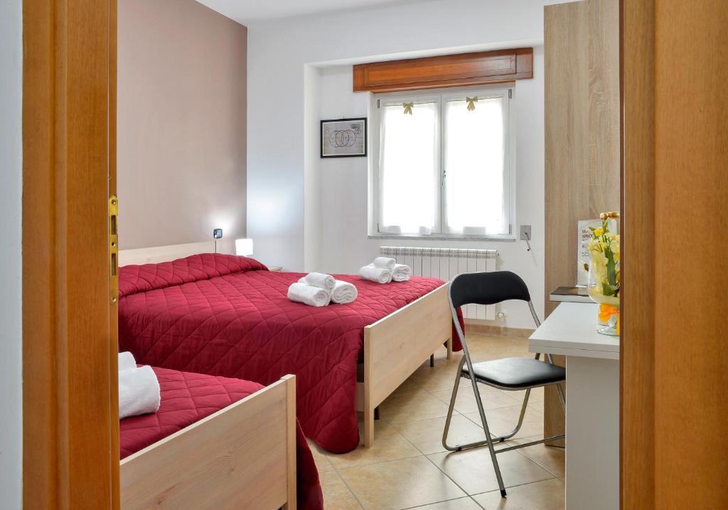 圣焦万尼因菲奥雷Mastro Gio的一间卧室设有两张床、一把椅子和一个窗户。